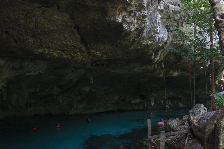 a group of people in boats floating into a cave