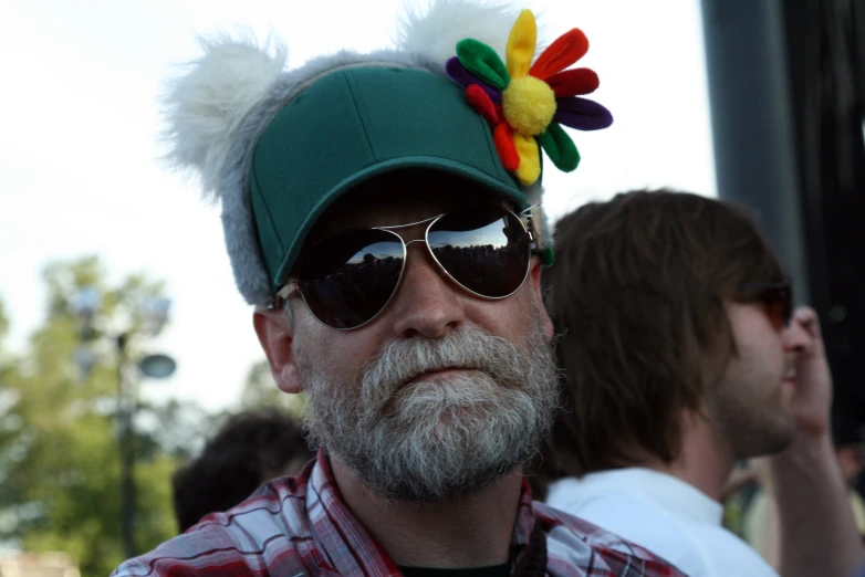 a man wearing sunglasses and a hat has an unusual hat on his head