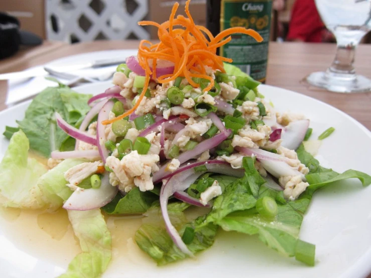 a salad is on a plate next to a beer