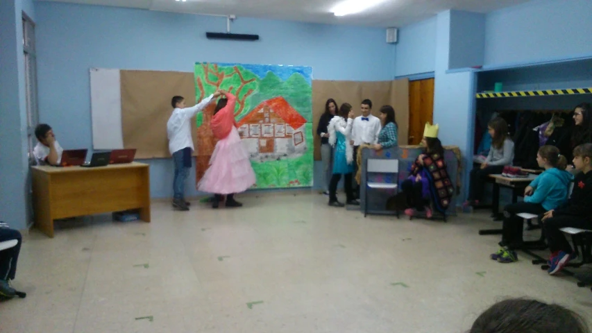 a group of young children standing around a painting