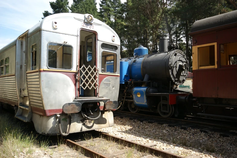 an old train is near two newer trains