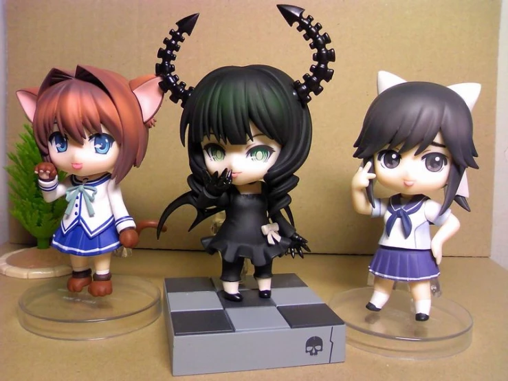 three anime figurines are displayed for sale