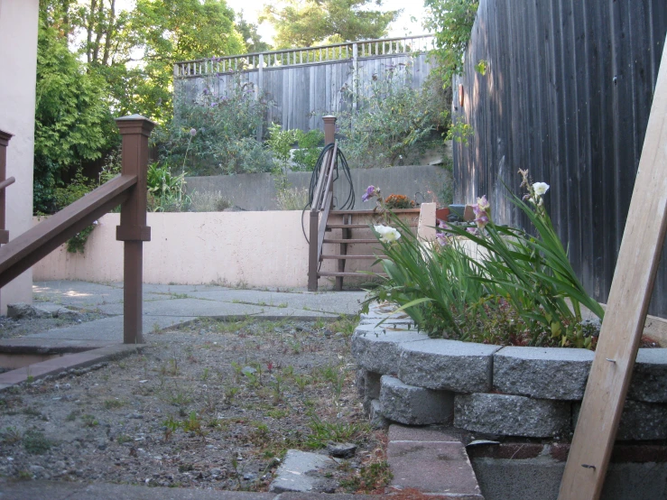 a garden with steps, flower bed and trees