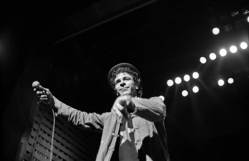 black and white po of man on stage with microphone