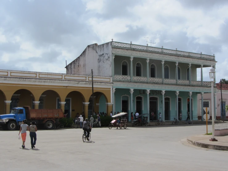 two people walking toward a building with lots of arches