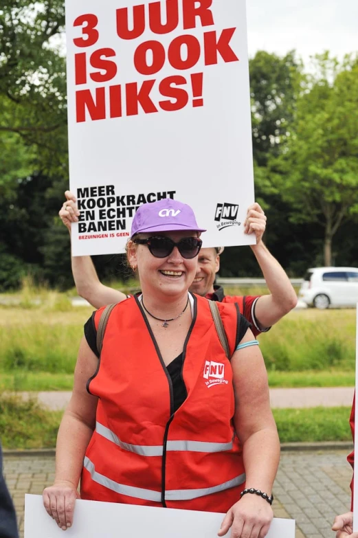 a woman holding a sign saying 3 uhr is look winks