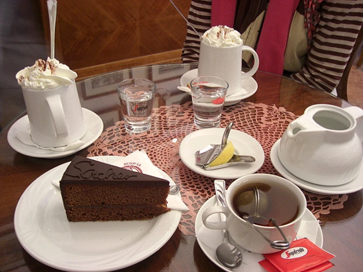 plate with cake, cup, and spoon and some coffee and water