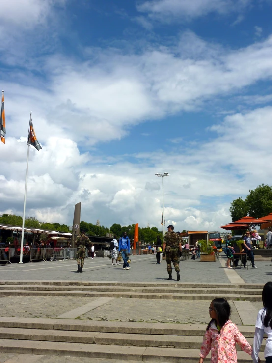 two s walk up a stone stairway towards an outdoor market with many tents