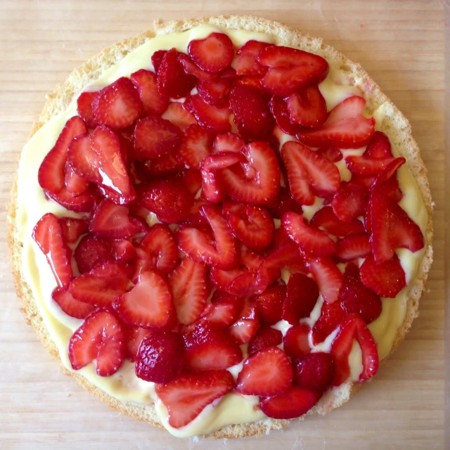 a dessert topped with strawberries on a wooden surface