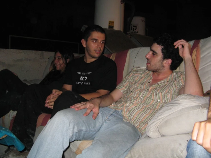 a group of people sitting on a couch at night