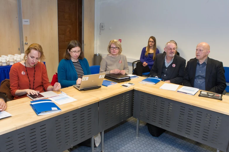 a group of people who are sitting in front of laptops