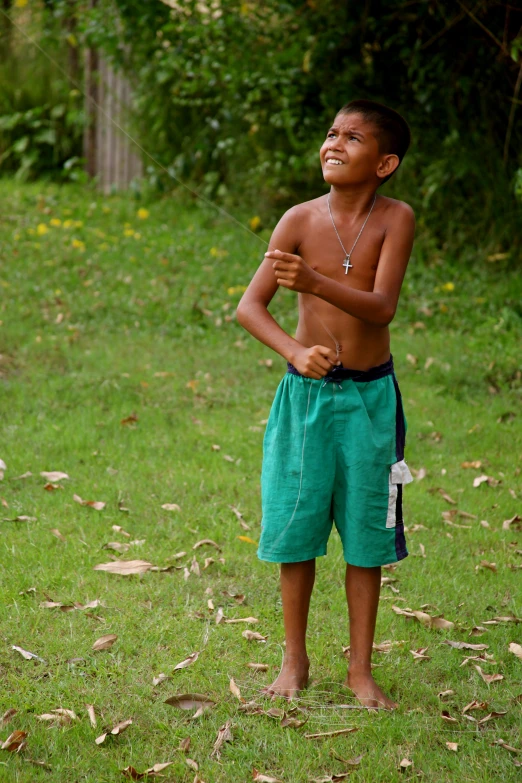  standing in grassy field with shirt open and jewelry hanging from chest