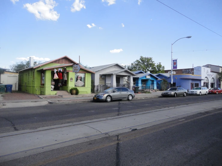 some houses are green and blue and some gray cars