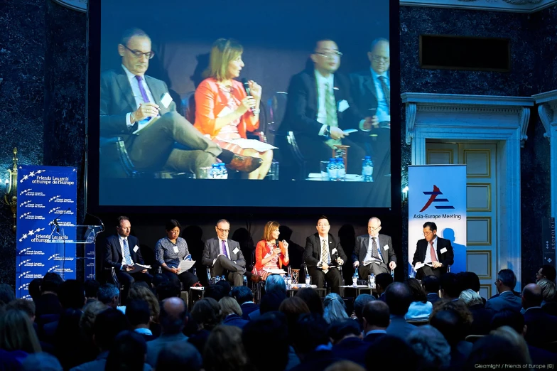 a group of people on stage in front of a screen