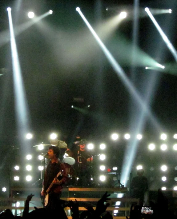 a band on stage with lights over their heads