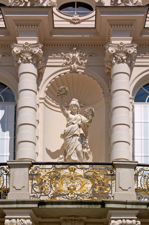 statue at top of the balcony of building