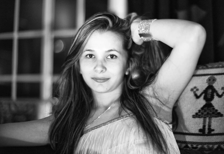 a woman smiling and posing for a black and white picture