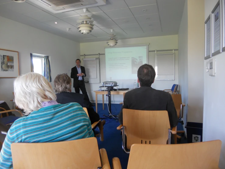 an audience listening to speakers at a business meeting