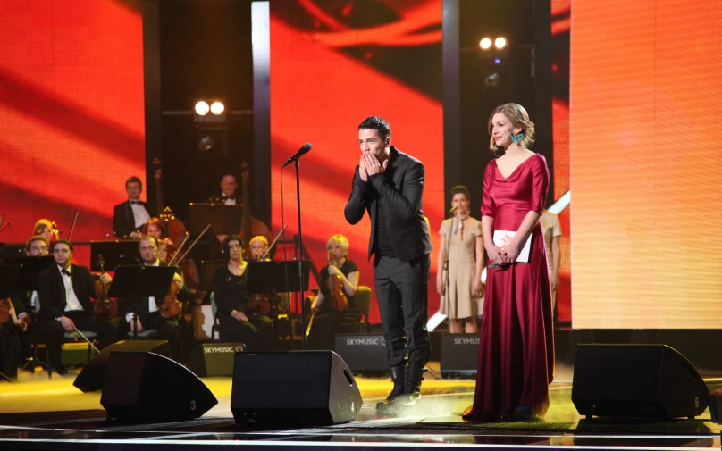 one man and woman stand in front of an audience