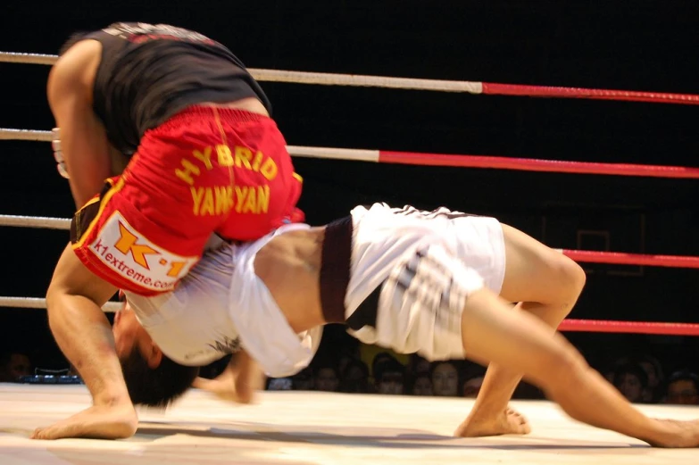 a man is in the middle of a fight and a referee has his legs outstretched