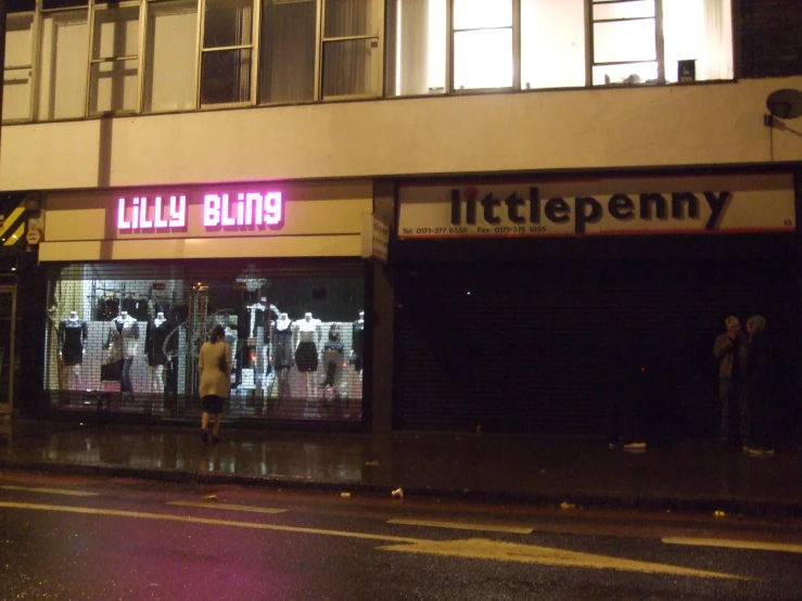 a man is standing out front of a small shop