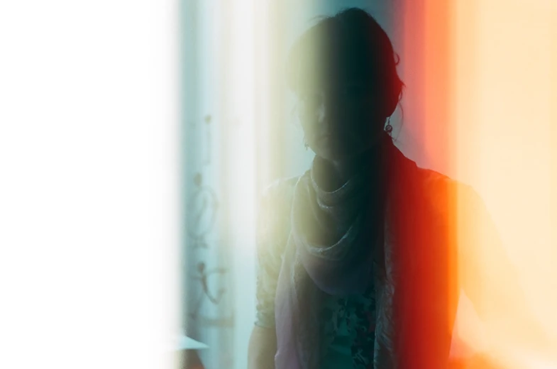 an abstract image with a person standing next to colored curtains