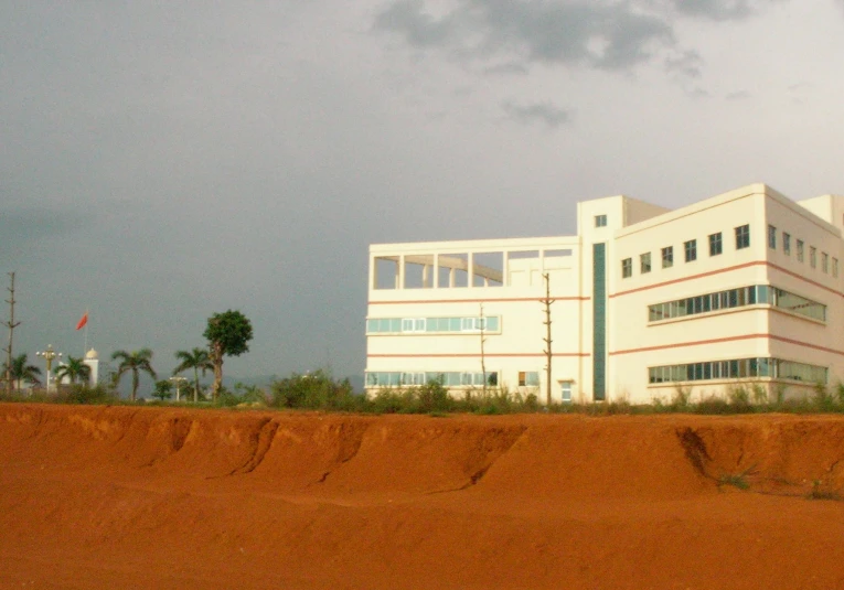 a large building with two windows next to a dirt field