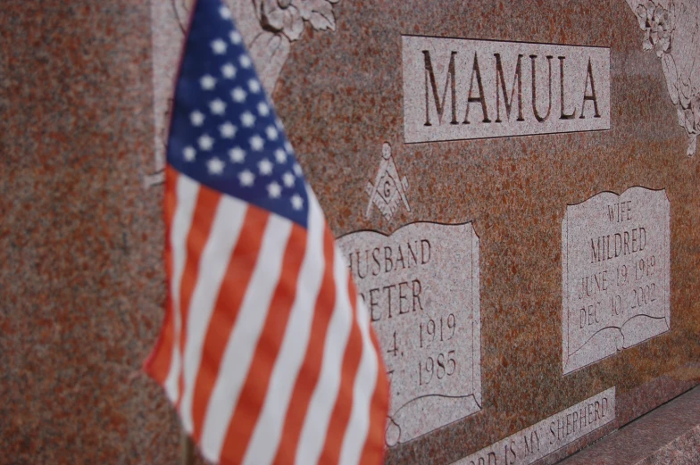 american flags decorate the memorial wall on memorial hill