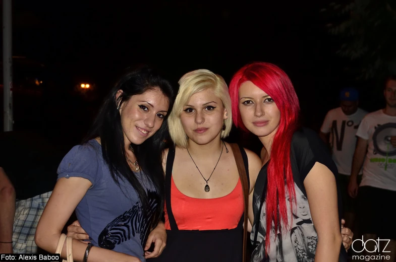 three young ladies posing for the camera at a party