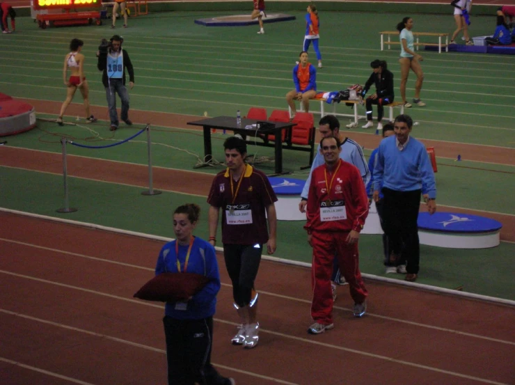 several athletes standing on a track and some on the side