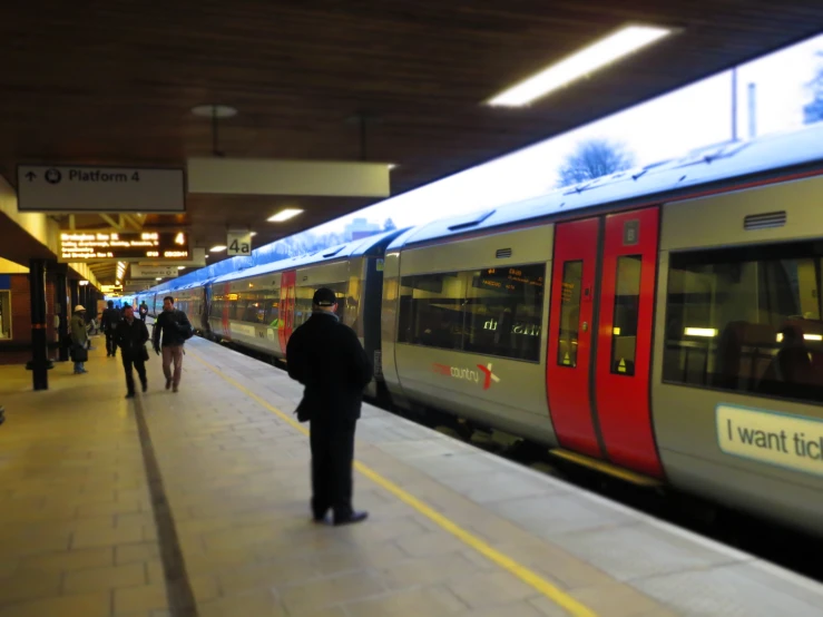 people walking in line at the platform near the train