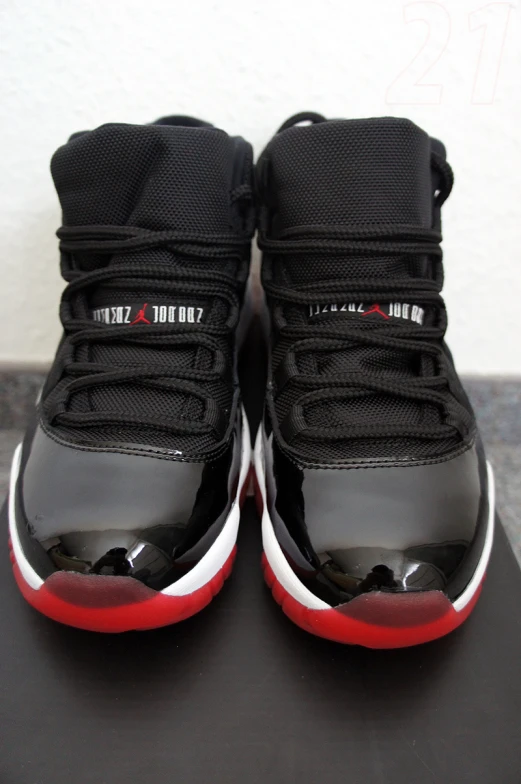 a pair of sneakers with red trim sitting on top of a black table