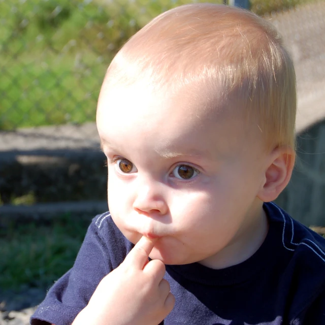 the small child is sitting on a bench and looking at the camera