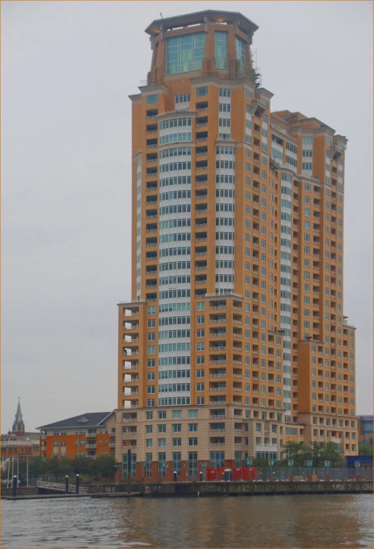 a tall building with many windows sits on the water