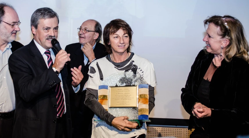 a woman receiving an award from some people