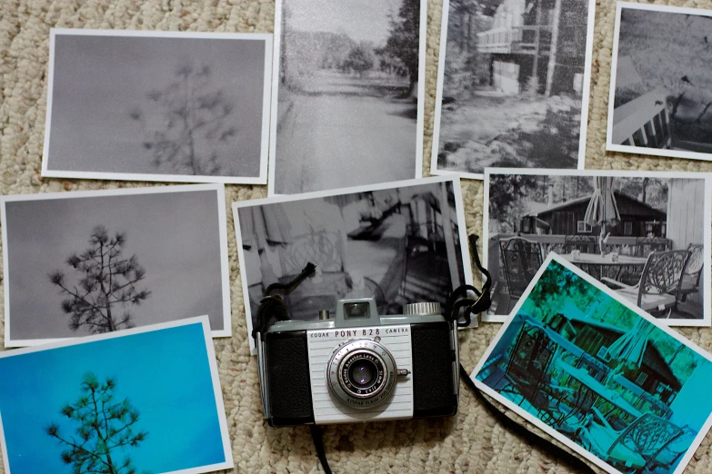 a camera and several old fashioned pos sitting on a rug