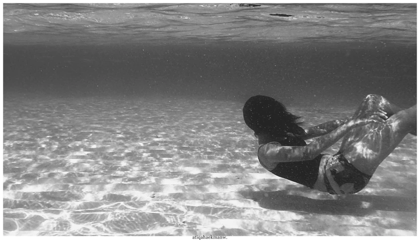 a woman is sitting in the clear water