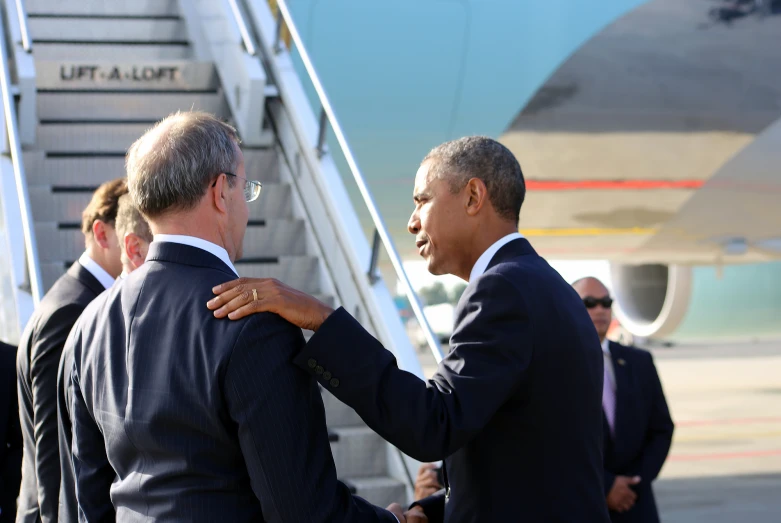 two men are standing close together as one gets dressed