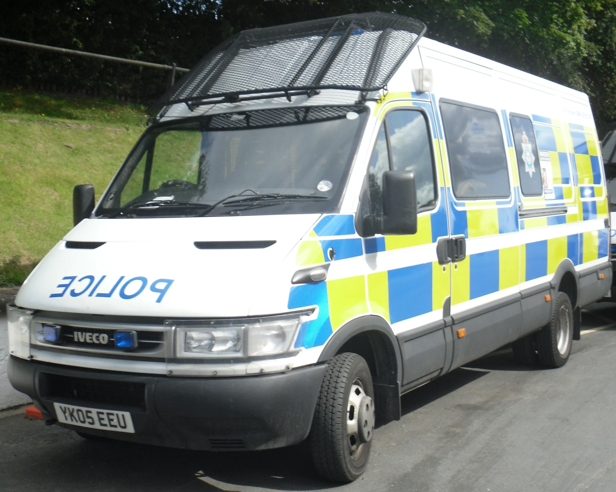 an ambulance with two large windows and a light on is parked beside a curb