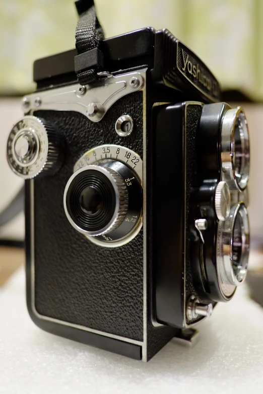 an old camera sitting on a table with an open lens