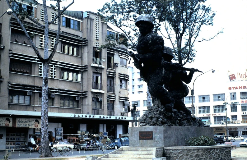 a statue of a man with a rifle standing in a plaza