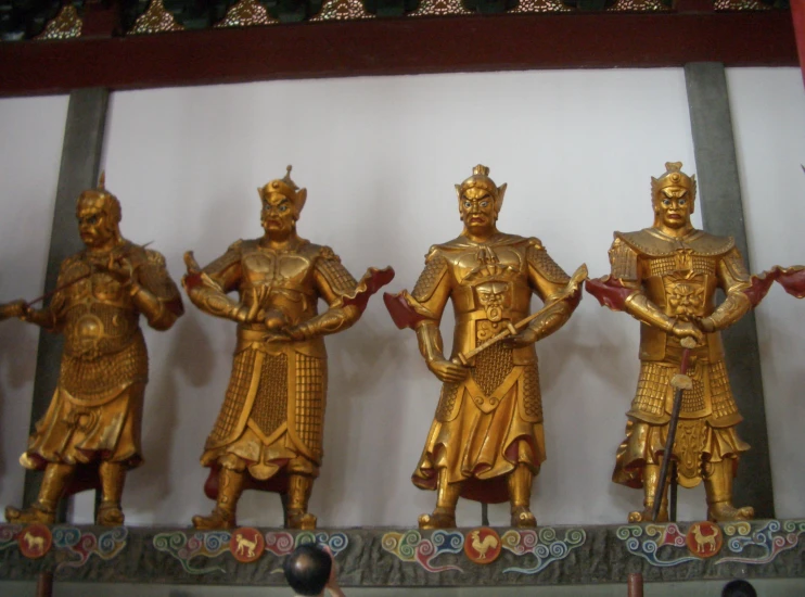 gold painted ss statues in a display case