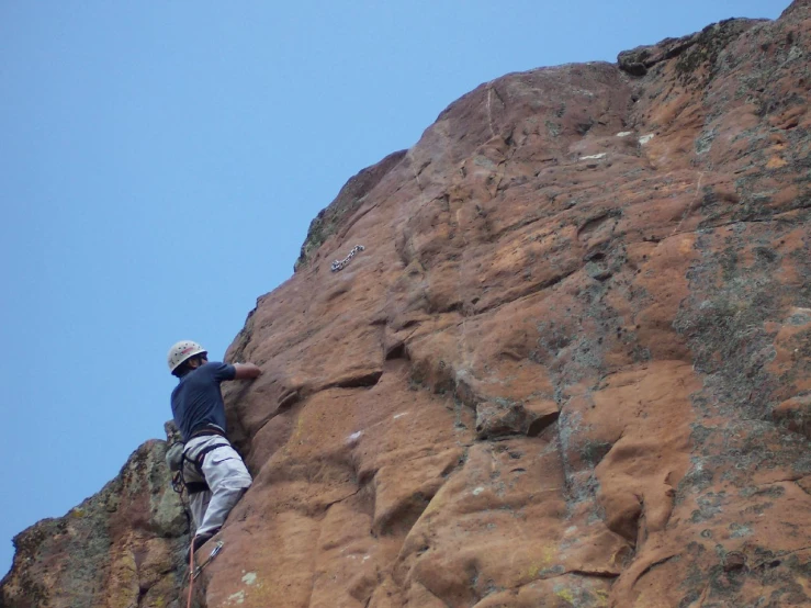 a man is climbing on the side of a rock