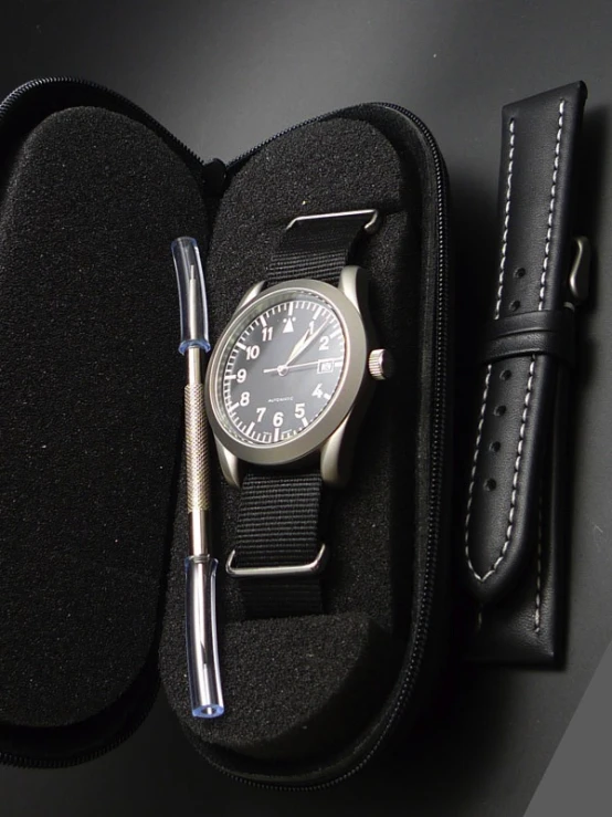 a watch in a case with a pen