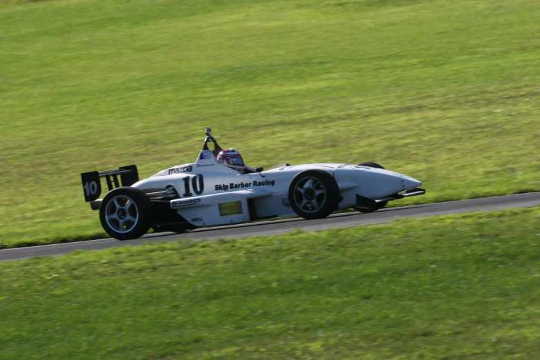 the racer drives along the race track on grass