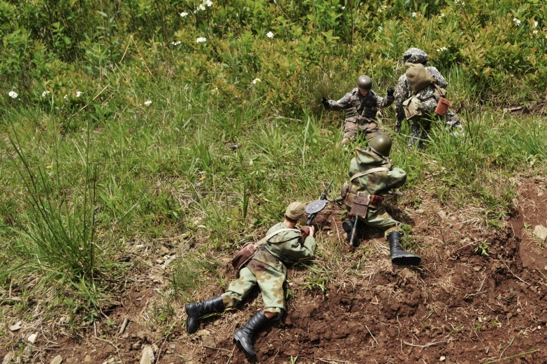 soldiers are laying in a field, in order to fight