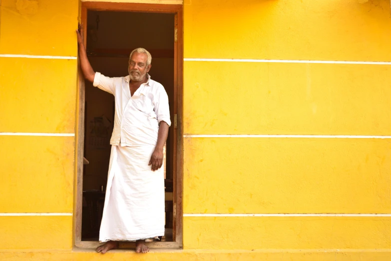 a man with a long robe is standing in an open window