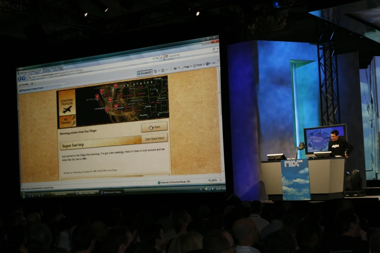 a screen on top of a big screen at a conference