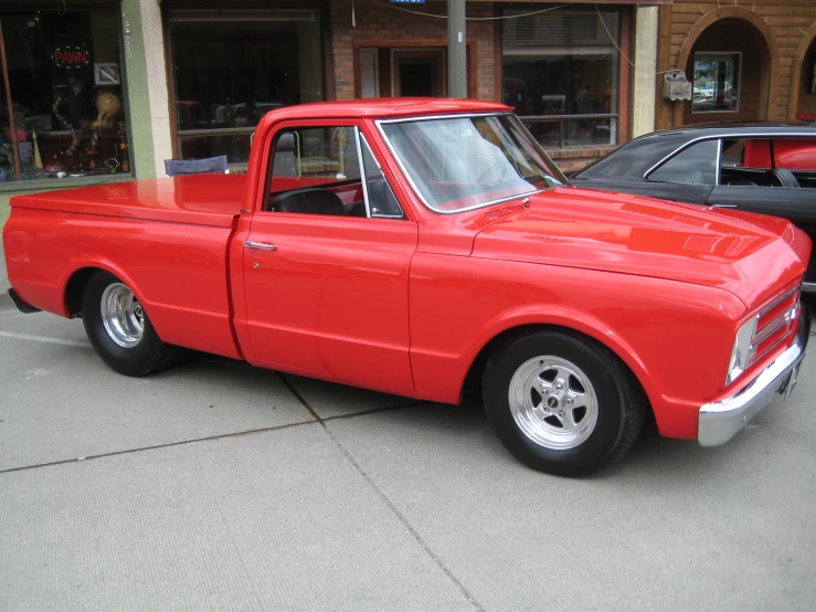 red classic pickup truck parked on city street