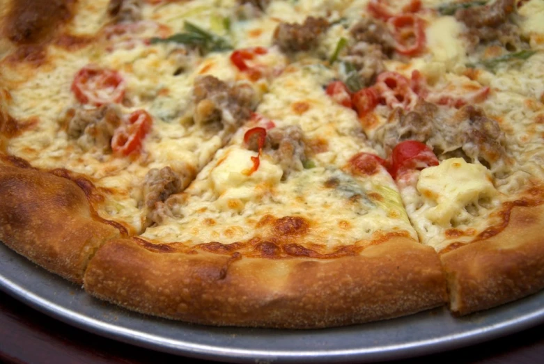 a pizza with tomato and meat toppings on a plate